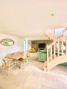 a living room with a wooden table and a staircase at La Chaumière en bord de mer in Trégastel