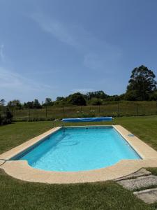 a swimming pool in the middle of a grass field at Villa Atlántica in Ribeira