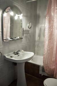 a bathroom with a sink and a mirror and a tub at Hospederia del Comendador in Ocaña