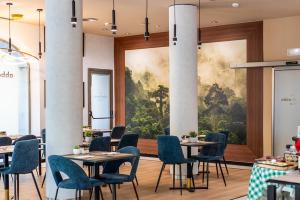 a restaurant with tables and chairs and a painting on the wall at Abba Rambla Hotel in Barcelona