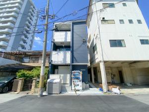 a tall white building with a sign in front of it at GLITTER302 Max 6ppl 5 minutes to USJ by train in Osaka