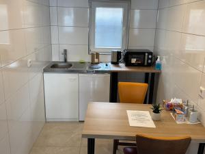 a small kitchen with a table and a sink at City Apart 2 Stadtwohnung mit NETFLIX Nahe Bahnhof in Sinsheim