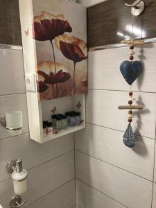 a bathroom with a painting of flowers on the wall at Aldebaran house in Nea Fokea +29 photos