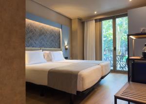 a bedroom with a large bed and a balcony at Abba Rambla Hotel in Barcelona +37 photos