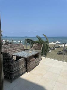 Un patio con mesa y sillas y la playa. en Sandy Kisses, en Lárnaca