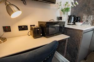 a microwave sitting on top of a table with a chair at Howth Harbour Cosy Retreat in Dublin