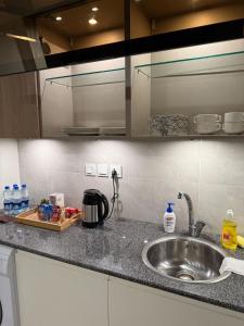 Una encimera de cocina con un fregadero y una encimera. en Penta Square Luxury Serviced Apartments DHA Phase 5, Lahore Modern Executive Stays, en Dargai