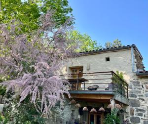 a building with a balcony on the side of it at Molinot Gîtes Nature & Confort in Alboussière