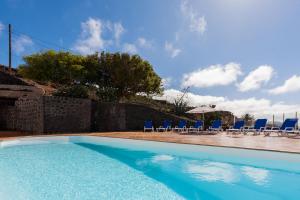 Los VallesにあるBellavista, piscina privada climatizada y saunaの椅子とパラソルのあるプール