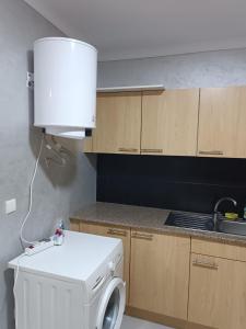 a white washing machine in a kitchen with a lamp at Appart Près de tout à Nador in Nador +3 photos