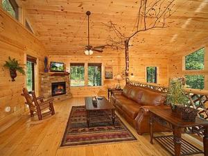 a living room with a couch and a table in a cabin at Snuggled Inn Holiday home in Gatlinburg