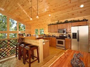a large kitchen with wooden cabinets and a white refrigerator at Snuggled Inn Holiday home in Gatlinburg