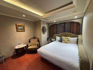 a hotel room with a bed and a chair at Tai Hope Hotel in Taipei