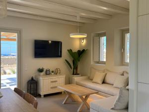 a living room with a couch and a tv at Sohoro Villas in Koufonisia