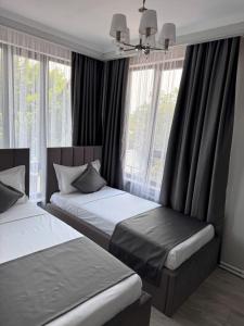 比什凯克Kausar Hotel的有两张床和一扇窗户的卧室