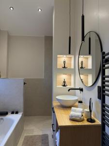 a bathroom with a sink and a tub and a mirror at 3Liebenauer Boutique Apartments in Worms +22 photos