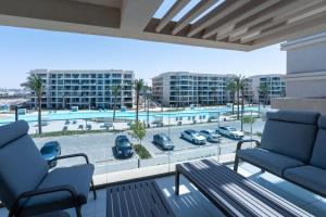 a balcony with two chairs and a view of a parking lot at BirdNest Vacation homes at Marassi marina in El Alamein