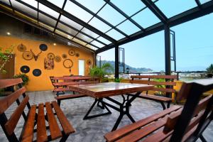 a patio with wooden tables and benches and windows at Green View Peak Restaurant in Gampola