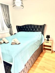 ein Schlafzimmer mit einem Bett mit einer blauen Bettdecke in der Unterkunft Apartman Lena in Vrnjačka Banja + 11 Fotos