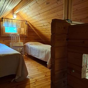 a bedroom with two beds in a log cabin at Lomahyppäys in Naantali