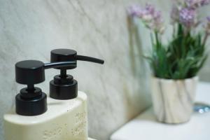 a bathroom sink with a faucet and a vase of flowers at Firdaus Huddersfield Town View Apartments in Huddersfield