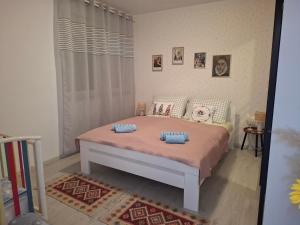 a bedroom with a bed with two pillows on it at Apartman ZORA s bazenom in Mostar +56 photos