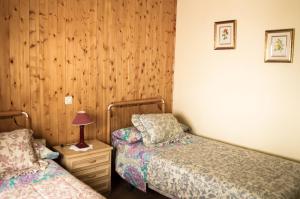 1 dormitorio con 2 camas y mesita de noche con lámpara en Hospederia del Comendador, en Ocaña
