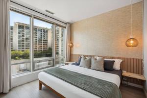 a bedroom with a bed and a large window at Cityview Suite near Robson Square and Canada Place for 6 Guests in Vancouver