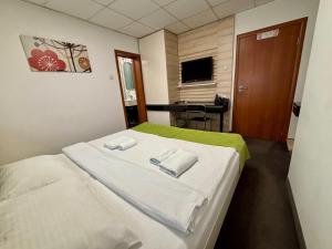 Ένα ή περισσότερα κρεβάτια σε δωμάτιο στο Garni Hotel Consul