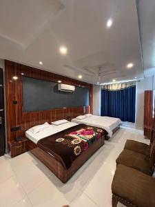 MirzāpurにあるHotel Milan Palaceのベッドルーム1室(ベッド2台、ソファ付)