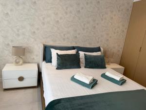 1 dormitorio con 1 cama con 2 almohadas verdes y blancas en BellaApartment, en Lagos 24 fotos más