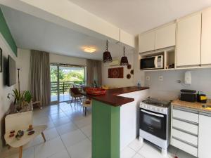 une cuisine avec des armoires blanches et un comptoir dans l'établissement Reserva Imbassaí Apartamento 1 quarto área de churrasco Bl2202, à Mata de São João 24 autres photos