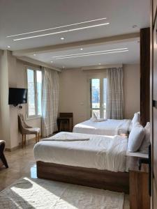 ein großes Schlafzimmer mit 2 Betten und einem TV in der Unterkunft Ra Palace Pyramids View Hotel in Kairo