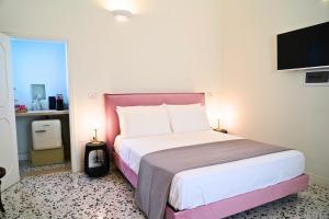 a bedroom with a large bed and a tv on the wall at Palazzo Sozzi Luxury - ANTICO SPLENDORE nel CUORE di OSTUNI in Ostuni