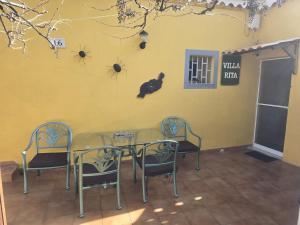 a dining room with a table and chairs against a yellow wall at Villa Rita in Cueva Grande