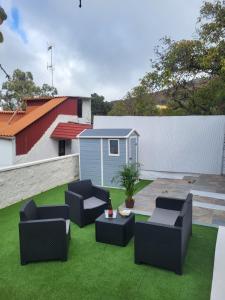 a patio with two chairs and a table on grass at Villa Rita in Cueva Grande