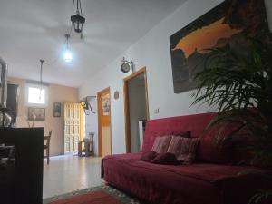 a living room with a red couch and a plant at Villa Rita in Cueva Grande