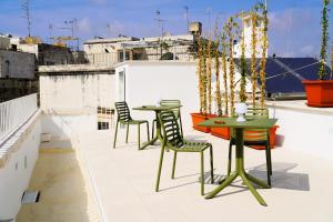 a patio with two tables and chairs on a roof at Palazzo Sozzi Luxury - ANTICO SPLENDORE nel CUORE di OSTUNI in Ostuni