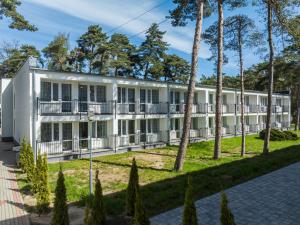 an exterior view of a building with trees at DIUNA Łeba in Łeba