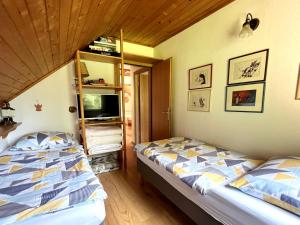a bedroom with two beds and a book shelf at Panoramic Forest Chalet Bled Lake and Castle View in Bled +9 photos