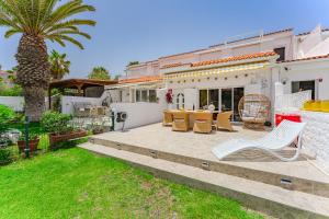 a house with a patio with a table and chairs at Ocean View Duplex Tenerife ( Golf del Sur) in San Miguel de Abona