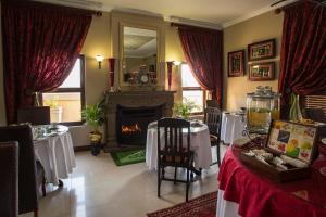 a dining room with two tables and a fireplace at The Royal Palm B&B in Ohrigstad