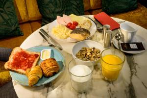 Una mesa cubierta con platos de desayuno y bebidas. en Dansaert Hotel, en Bruselas