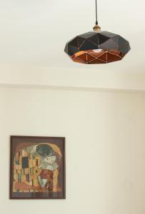 aendant light hanging from a ceiling with a painting at Aronia Kazbegi in Stepantsminda