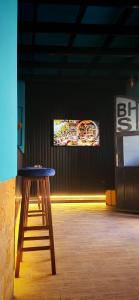 a stool in a room with a tv on the wall at Blue Stone H in Madaba
