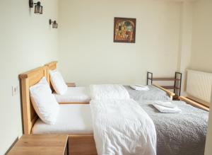 a bedroom with two beds with white sheets at Aronia Kazbegi in Stepantsminda