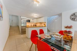 a kitchen and dining room with a glass table and red chairs at Ocean View Duplex Tenerife ( Golf del Sur) in San Miguel de Abona
