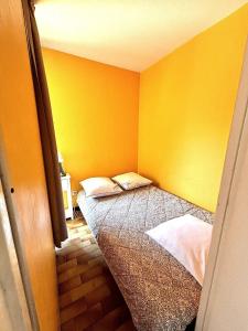 a bedroom with yellow walls and a bed at Appartment Cap d'Agde in Cap d'Agde +2 photos