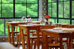 a row of wooden tables and chairs in a restaurant at Swiss Holidays in Pinangode
