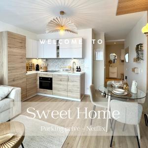 Una cocina y una sala de estar con una mesa y un sofá. en Sweet Home - Cocon élégant, balcon & parking privé, en Chambéry